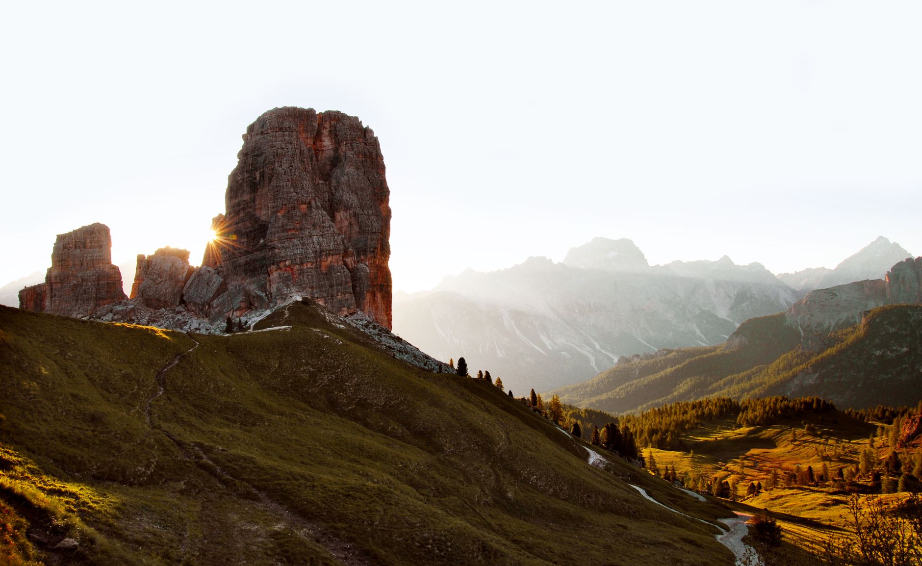 Dolomites peaks bathed in morning mist and warm sunlight
